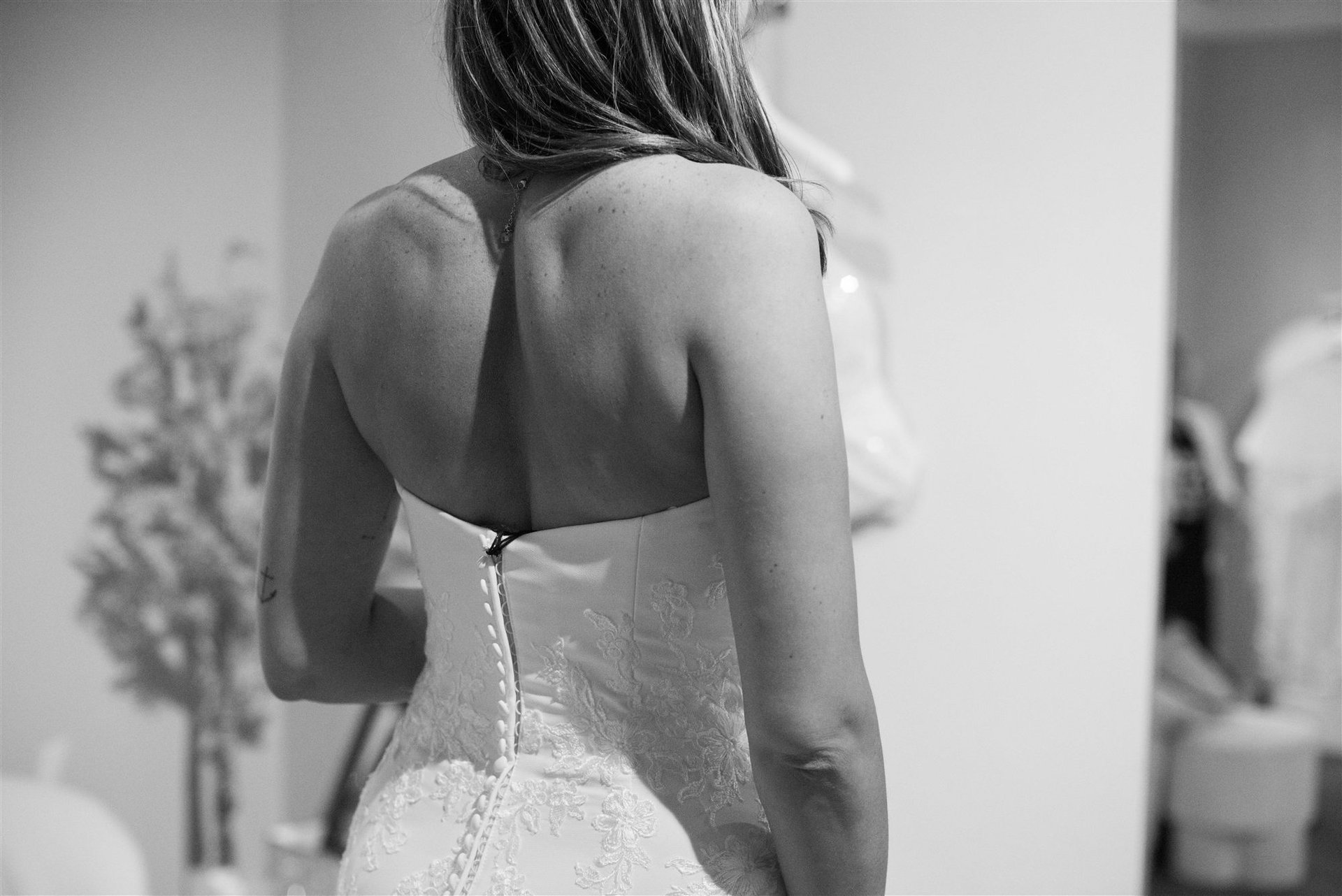 Détail fermeture dos de la robe dentelle bustier lors de l'essayage à Perpignan