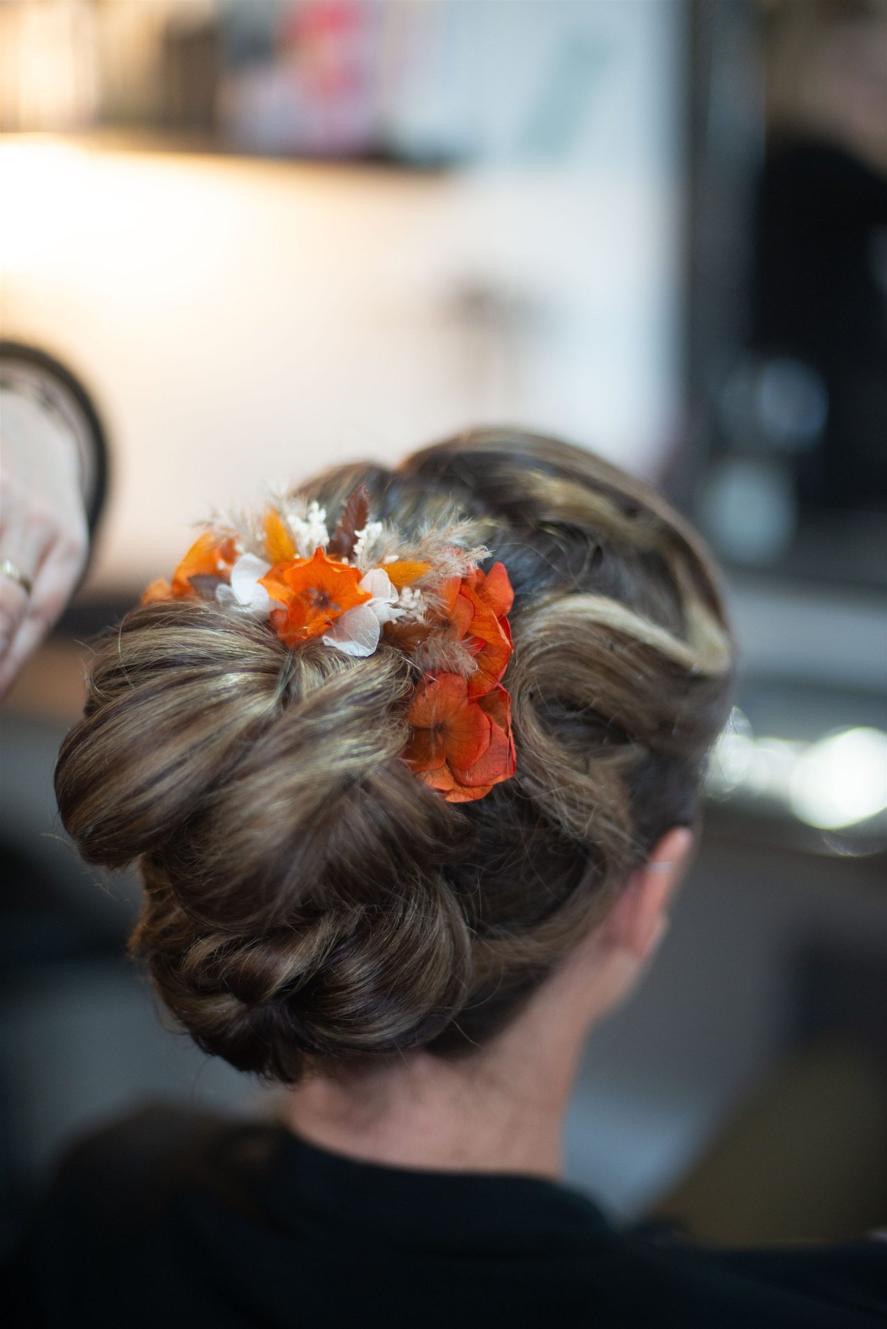 Chignon fleuri finalisé vu de dos — composition florale Mille Fleurs Sauvages, coiffure mariage Perpignan