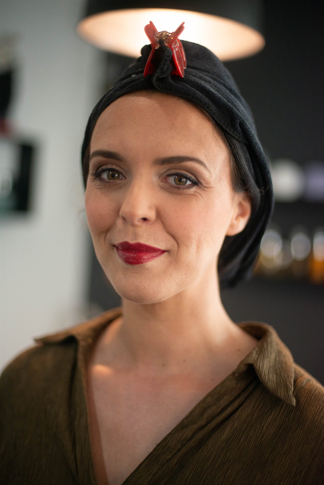 Portrait d'Amandine maquillée — lèvres bordeaux, serviette noire, regard posé — Salon D'Ana Perpignan