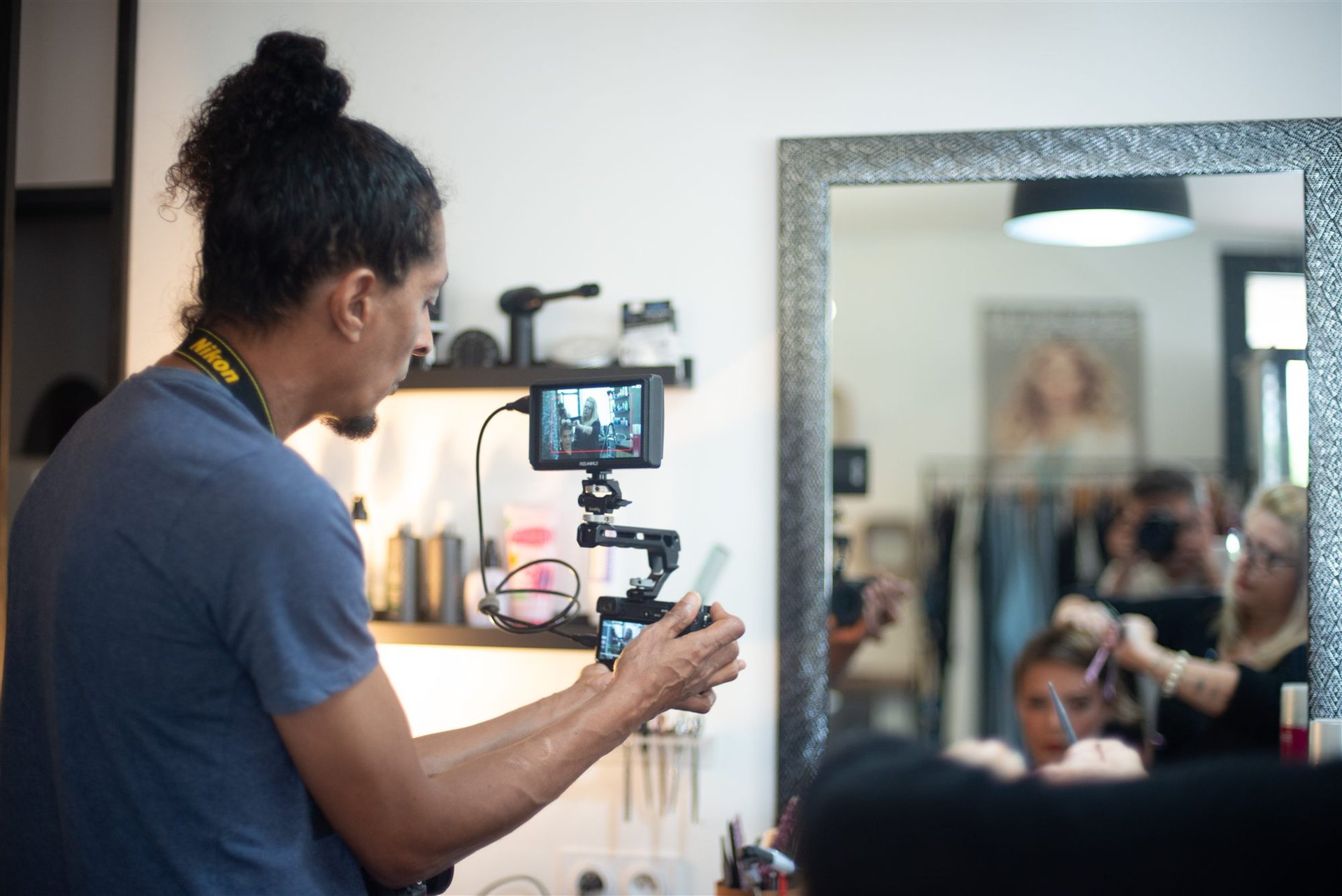 Le vidéaste Oziris Films filme la coiffure d'Amandine, reflet dans le grand miroir du Salon D'Ana