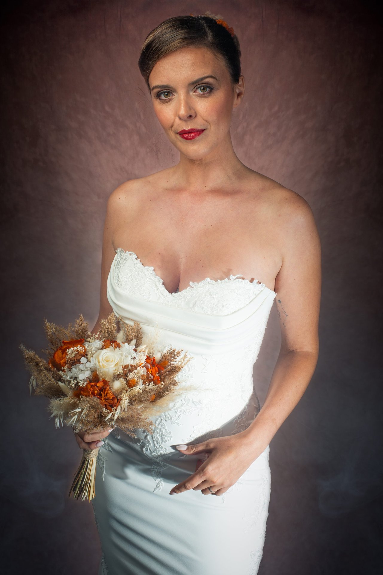 Portrait studio de la mariée Amandine en robe bustier dentelle blanche, bouquet de fleurs séchées, lèvres rouges — photographe mariage Perpignan